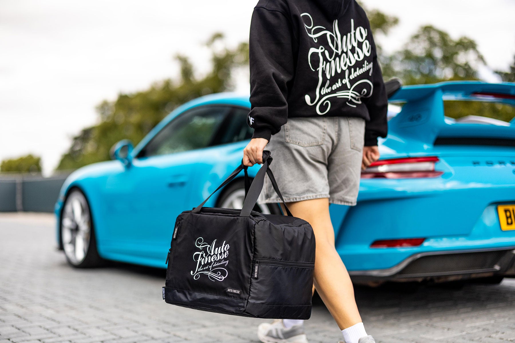 Man Holding New Kit Bag_ Wearing Oversized Signature Hoodie